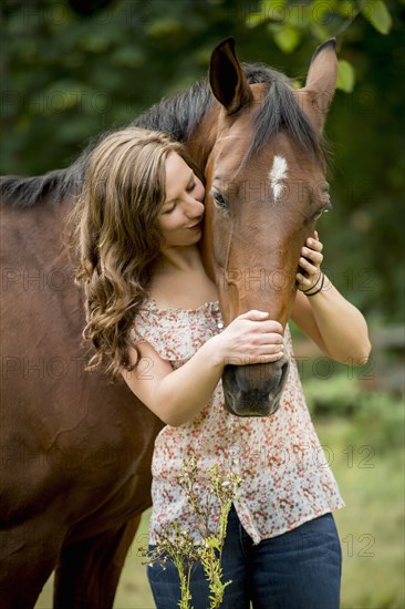 Caucasian woman walking horse outdoors