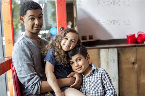 Mixed race brothers and sister smiling together