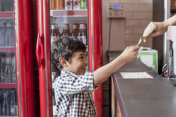 Mixed race boy buying food in restaurant