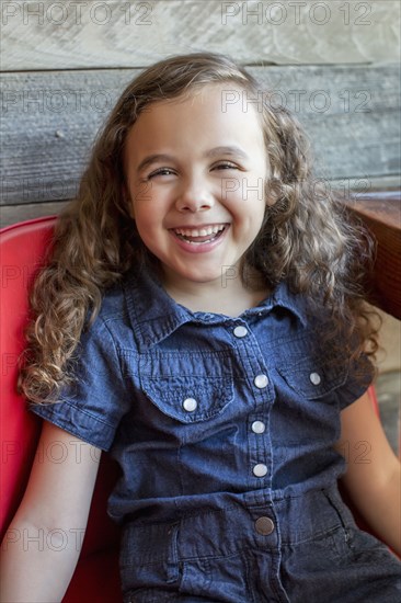 Smiling mixed race girl sitting in chair
