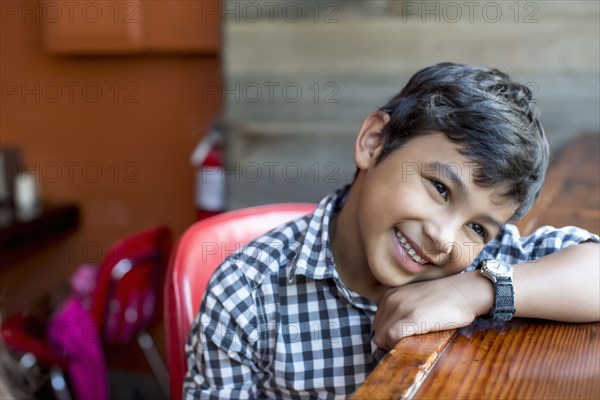 Mixed race boy leaning on bar