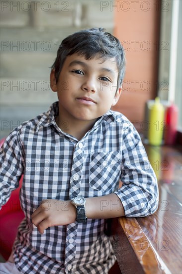 Mixed race boy sitting in restaurant