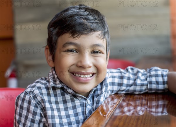 Mixed race boy sitting in restaurant