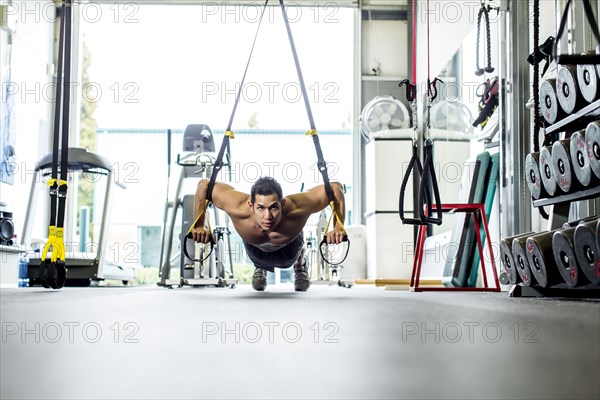 Pacific Islander man working out in gym