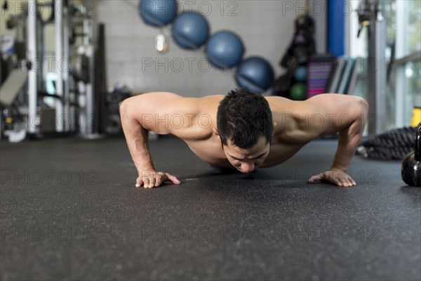 Pacific Islander man working out in gym