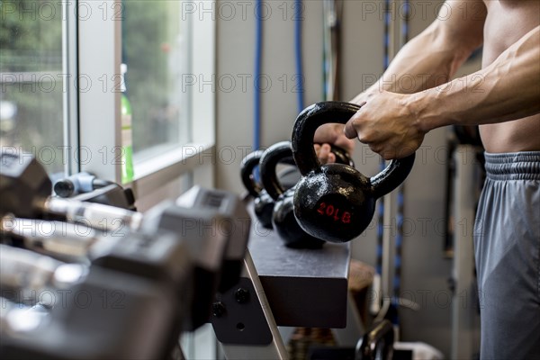 Pacific Islander man lifting weights in gym