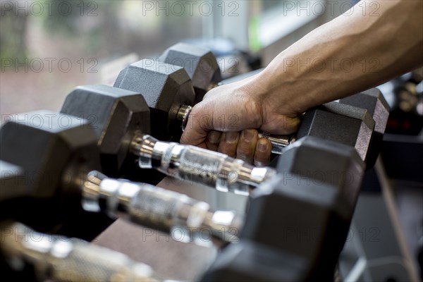 Pacific Islander man lifting weights in gym