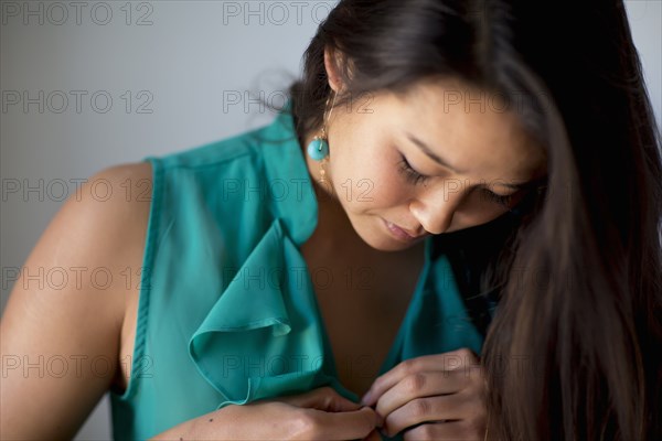 Japanese woman buttoning her blouse