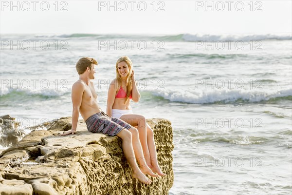Couple relaxing on rocky beach