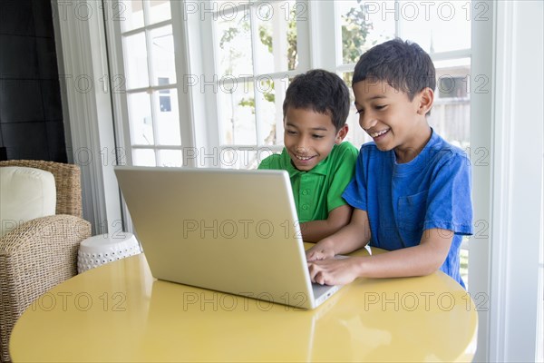 Hispanic boys using laptop