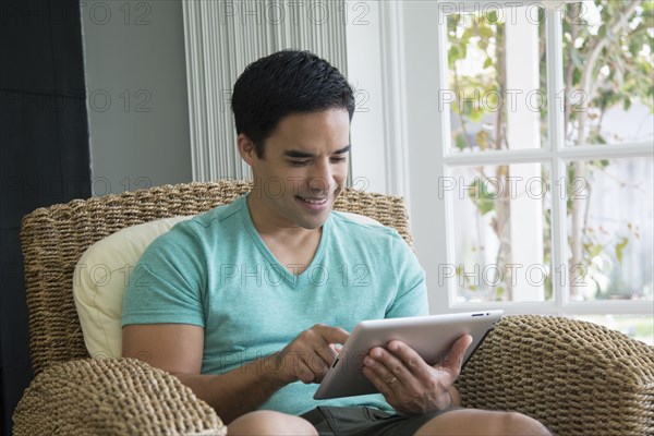 Hispanic man using digital tablet
