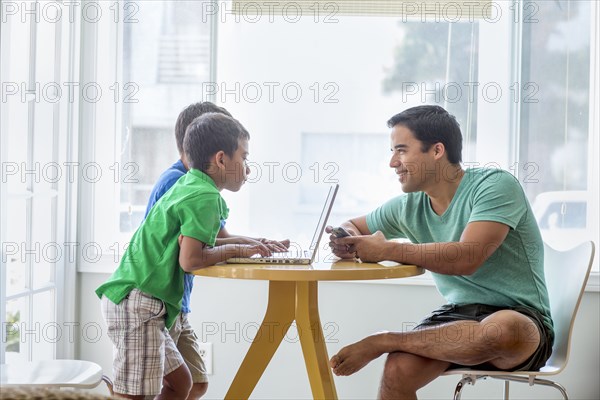 Father and sons talking at table