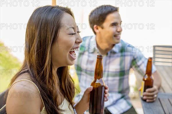 Couple having beers in backyard