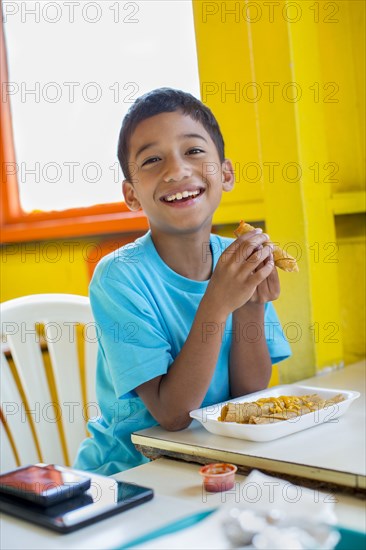 Hispanic boy eating in restaurant