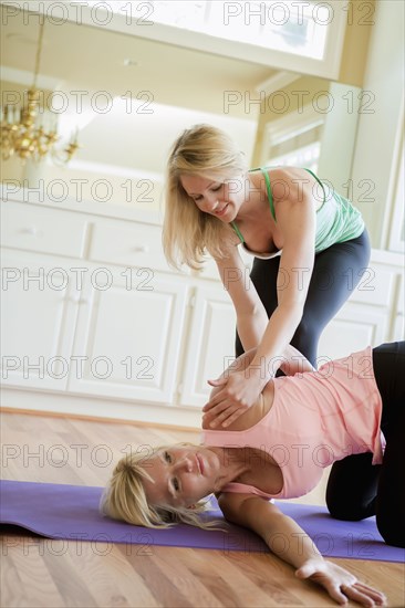 Caucasian woman working with yoga instructor in home