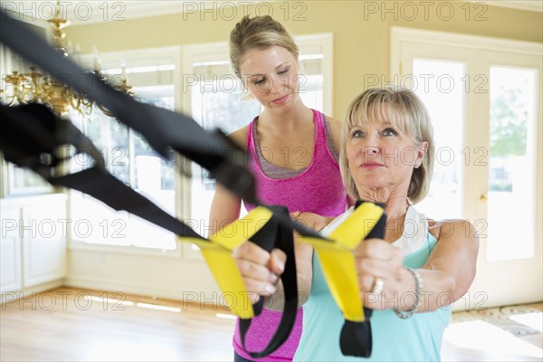 Caucasian woman working with trainer in home