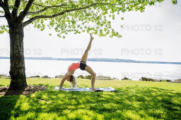 Caucasian woman practicing yoga outdoors