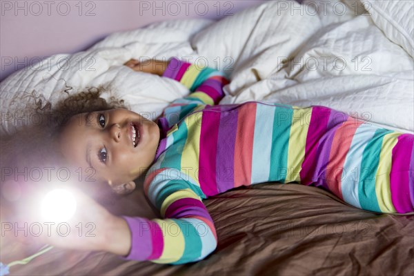 Mixed race girl smiling on bed