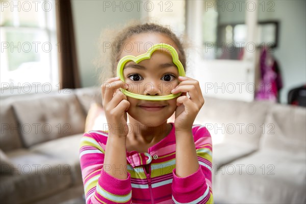 Mixed race girl playing with cookie cutter