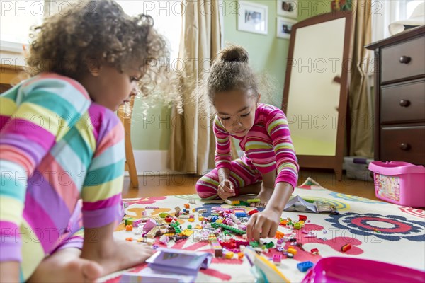 Mixed race girls playing in bedroom