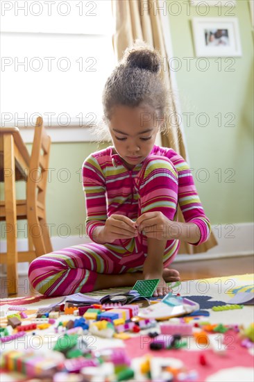 Mixed race girl playing in kitchen