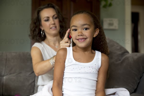 Mother fixing daughter's hair