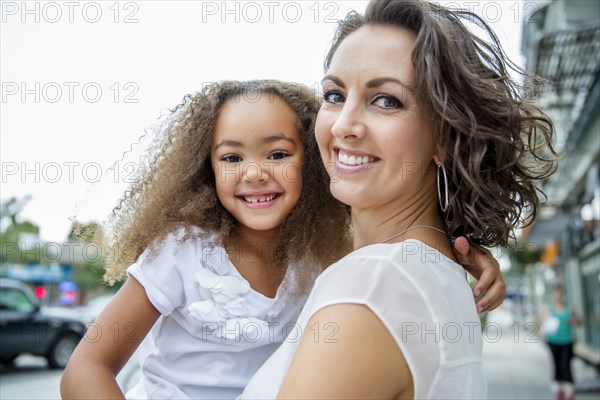 Mother and daughter smiling outdoors