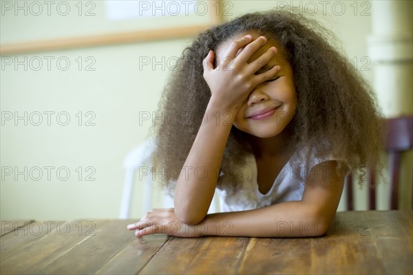 Mixed race girl laughing at table