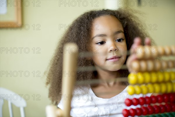 Mixed race girl using abacus