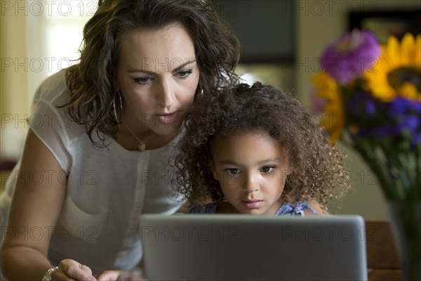 Mother and daughter using laptop