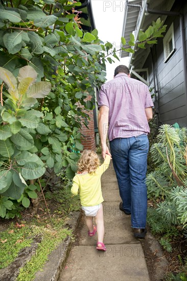 Father and daughter walking in backyard