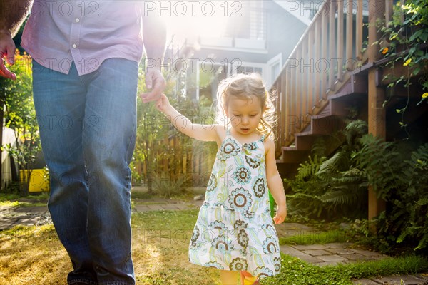 Father and daughter walking in backyard