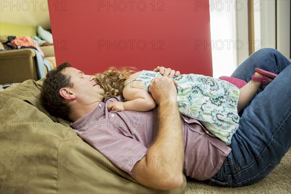 Father and daughter relaxing in living room