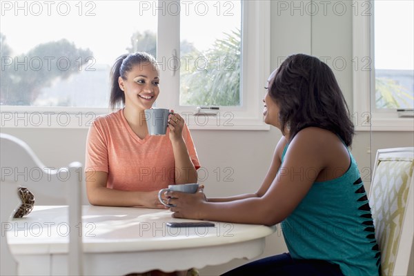 Women drinking coffee together at table