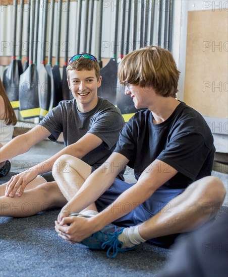 Caucasian boys stretching in boathouse