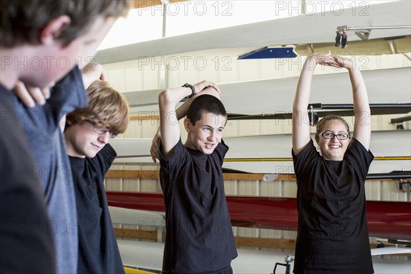 Caucasian teenagers stretching in boathouse