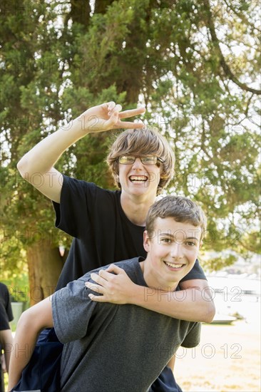 Caucasian teenage piggybacking in park