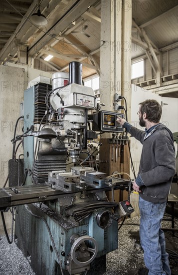 Caucasian man using machinery in metal shop