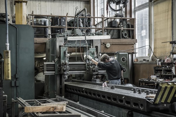 Caucasian man using machinery in metal shop