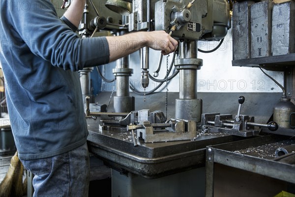 Caucasian man using drilling machine in workshop