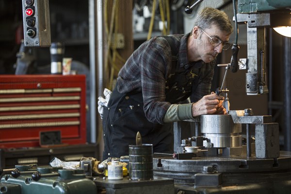 Caucasian man using machinery in workshop