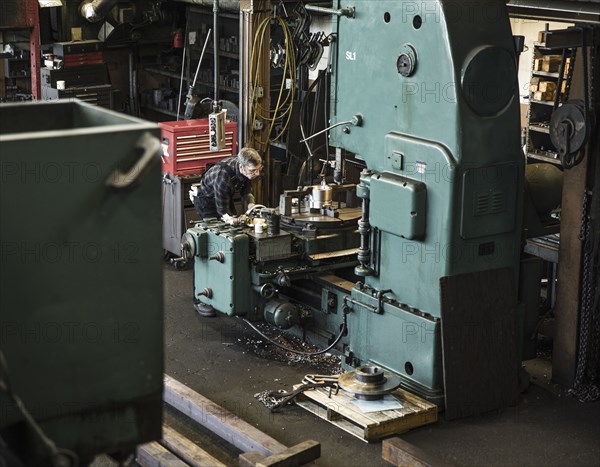 Caucasian man using machinery in workshop