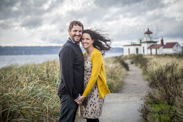 Caucasian couple hugging on beach path