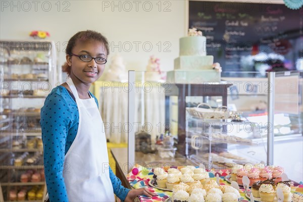 Mixed race girl baking in commercial kitchen
