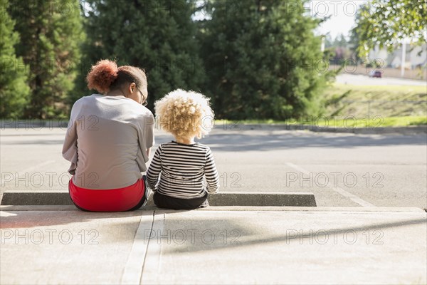 Mixed race sisters sitting outdoors