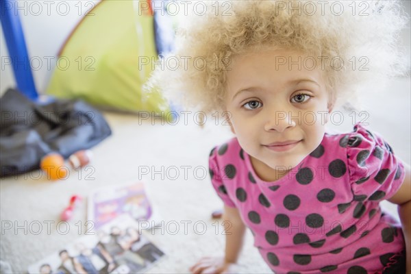 Mixed race girl smiling on floor