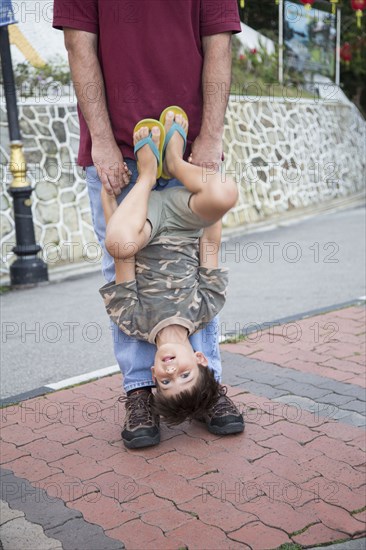 Caucasian father and son playing on city street