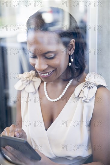 Black businesswoman using digital tablet on train