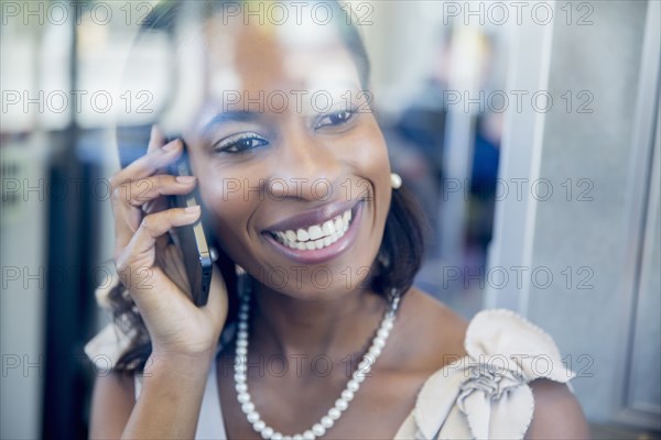 Black businesswoman talking on cell phone on train