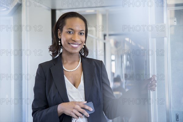 Black businesswoman smiling on train